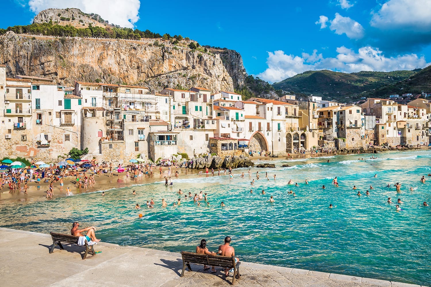 People on beautiful beach at the bay in Cefalu, Sicily
