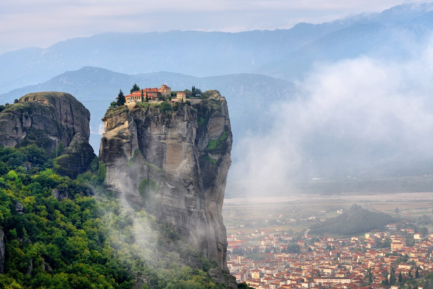 Meteora monasteries. Beautiful view on Monastery of the Holy Trinity placed on the edge of high rock covered of the morning at sun rises, Kastraki, Greece
