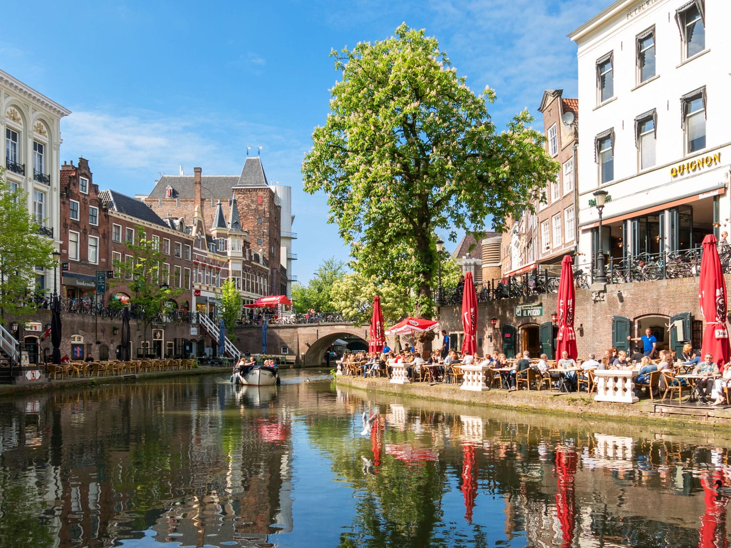 Oudaen Castle and people on outdoor terrace of restaurants alongside Oudegracht canal in the city of Utrecht, Netherlands