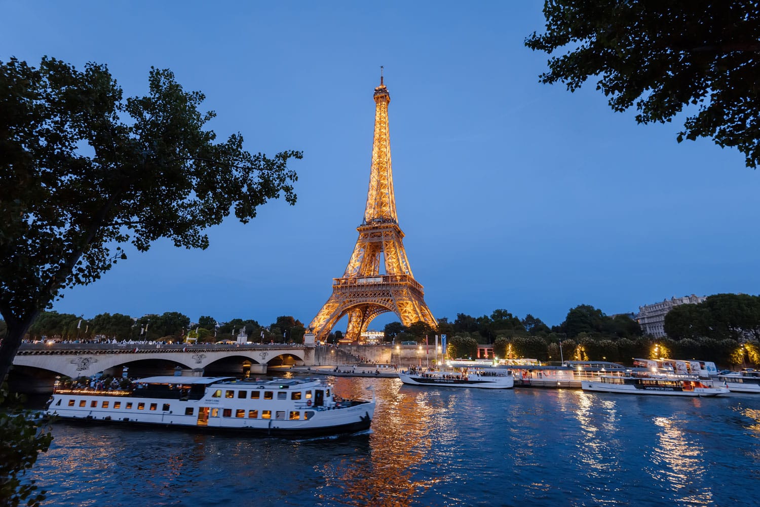 Πύργος του Άιφελ, κρουαζιερόπλοια και γέφυρα στον ποταμό Σηκουάνα τη νύχτα στο Παρίσι, Γαλλία