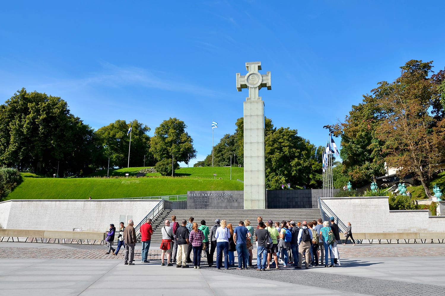 Tourists visiting Freedom Square, the War of Independence Victory Column in Tallinn, Estonia