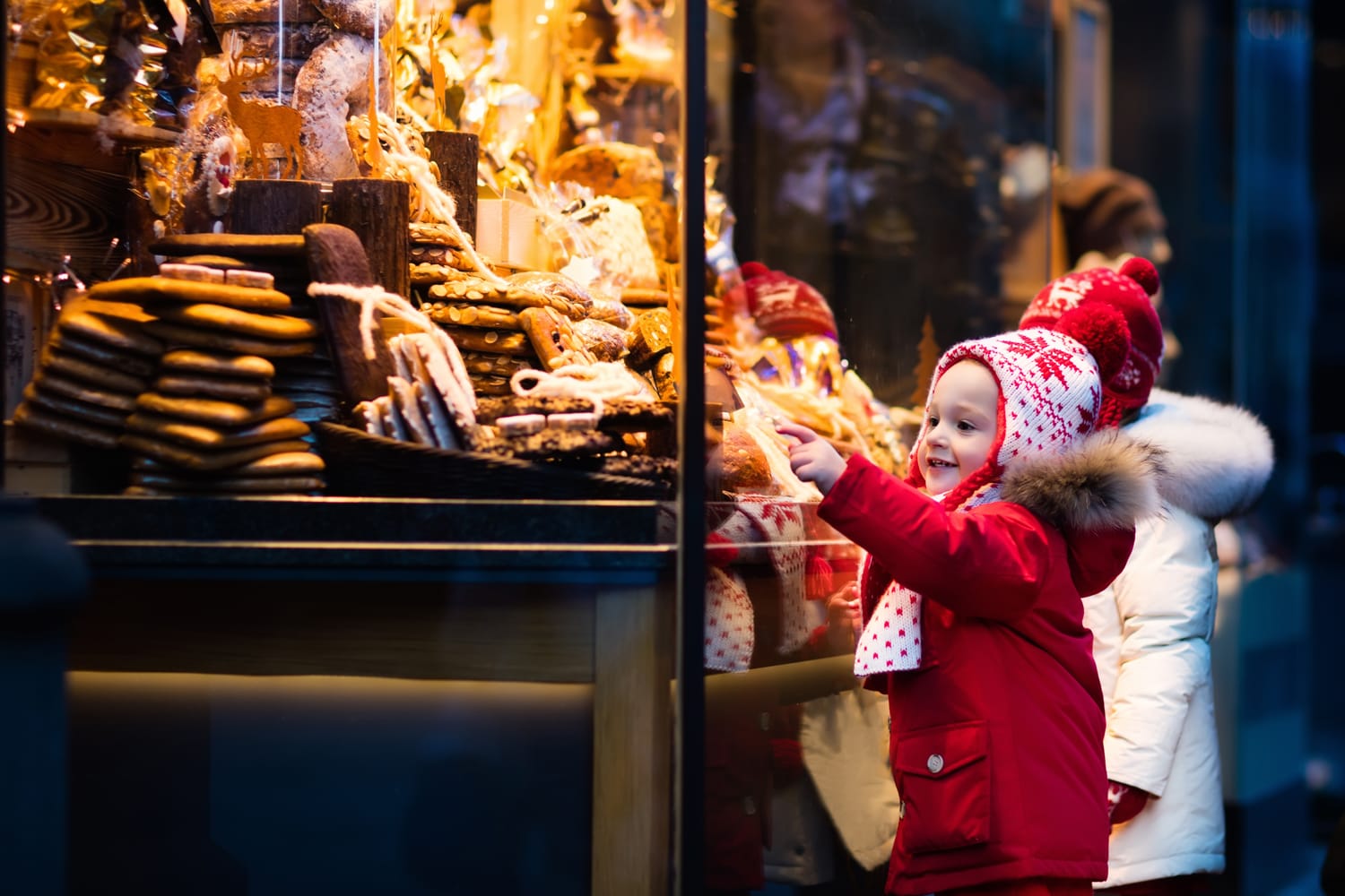 Children window shopping on traditional Christmas market in Germany on snowy winter day