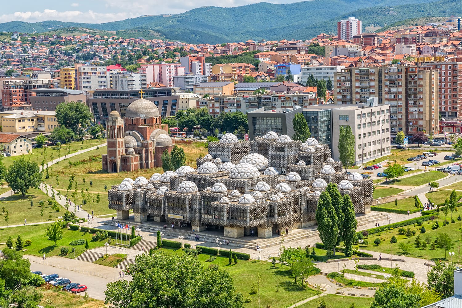 Aerial view of capital city with some old buildings like National Public Library and Christ the Saviour Cathedral. Pristina, Kosovo