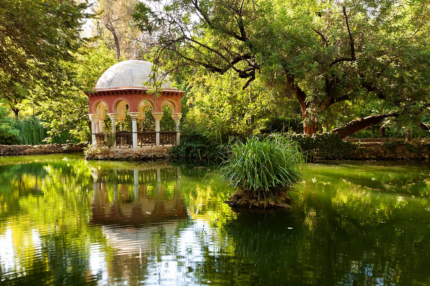 Romantic pavilion reflected in a pond. Parque Maria Luisa of Sevilla, Spain