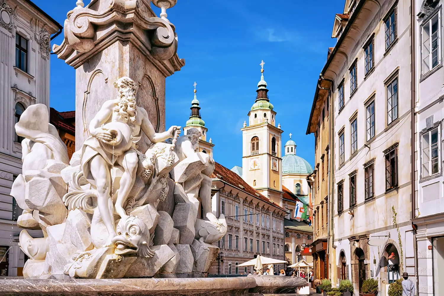 Fragment of Robba fountain in the historical center of Ljubljana, Slovenia. Ljubljana Cathedral on the background