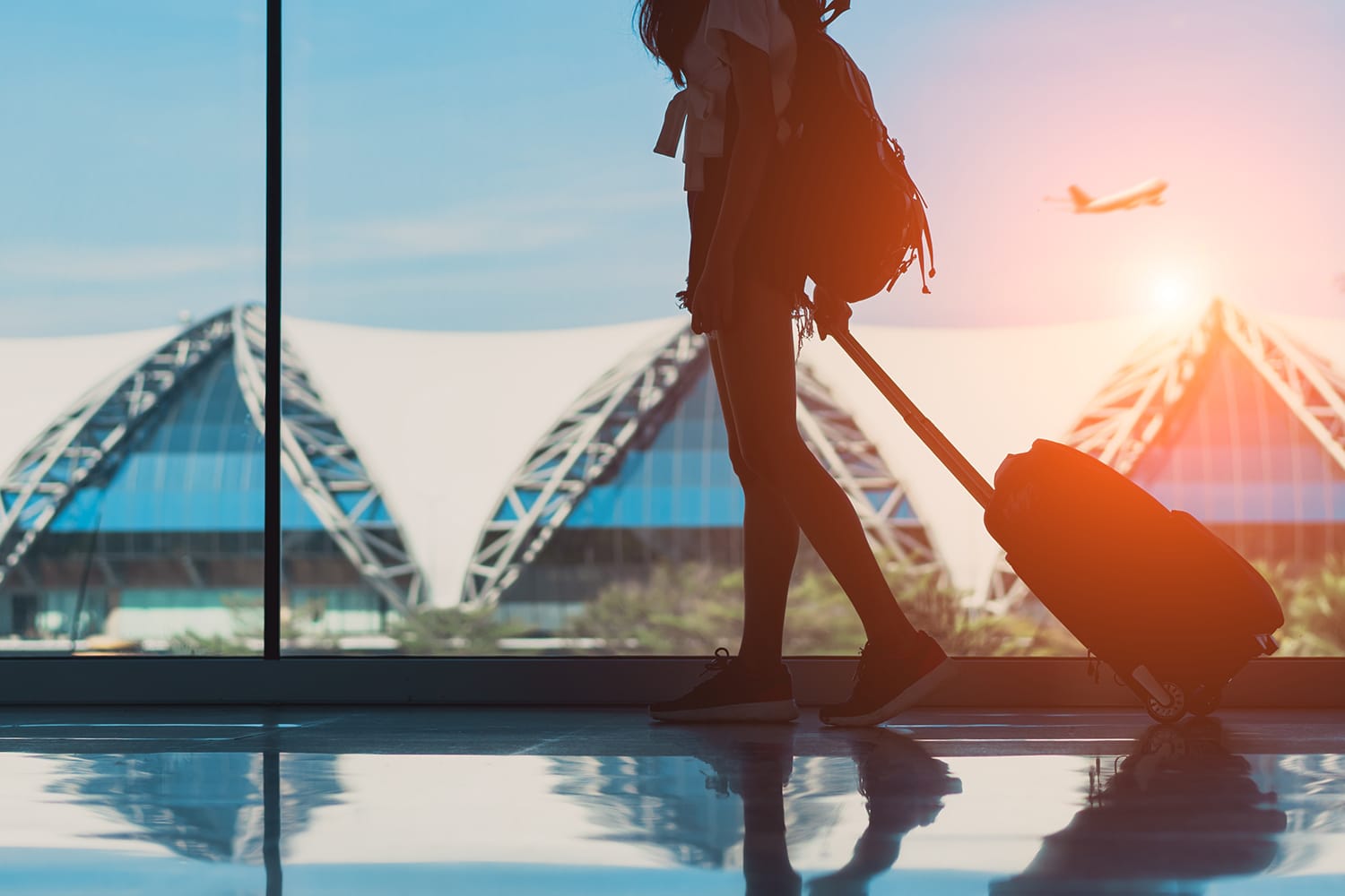 Γυναίκα σιλουέτα ταξιδεύει με αποσκευές που περπατά στο πλαϊνό παράθυρο στο αεροδρόμιο διεθνές τερματικό ή κορίτσι έφηβο που ταξιδεύει σε διακοπές καλοκαιρινής χαλάρωσης κρατώντας βαλίτσα και σακίδιο