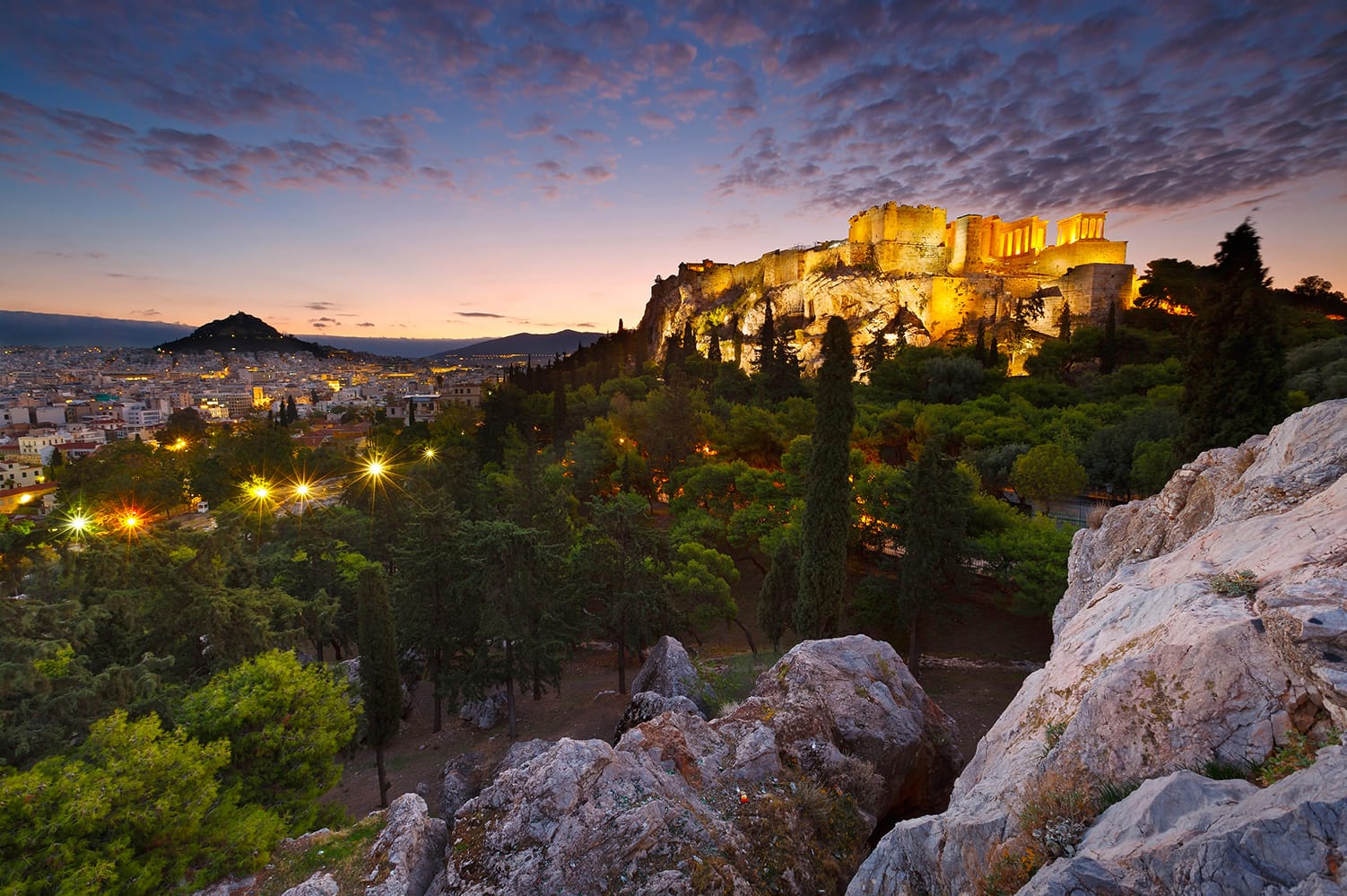 Sunset view of Acropolis and Lycabettus Hill from Areopagus hill in Athens, Greece