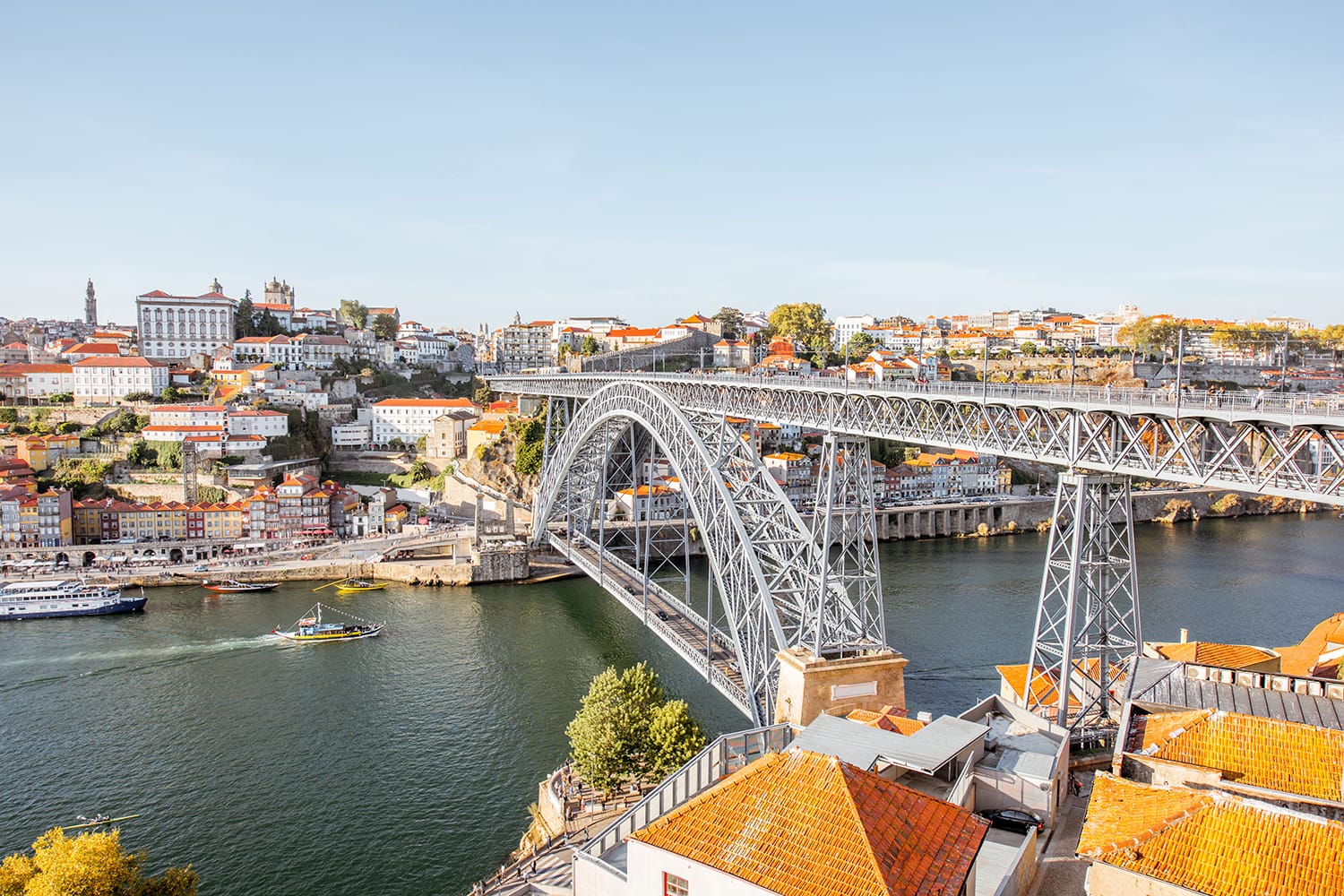 Landscape view the beautiful old town with famous iron bridge above the Douro river during the sunset in Porto city, Portugal