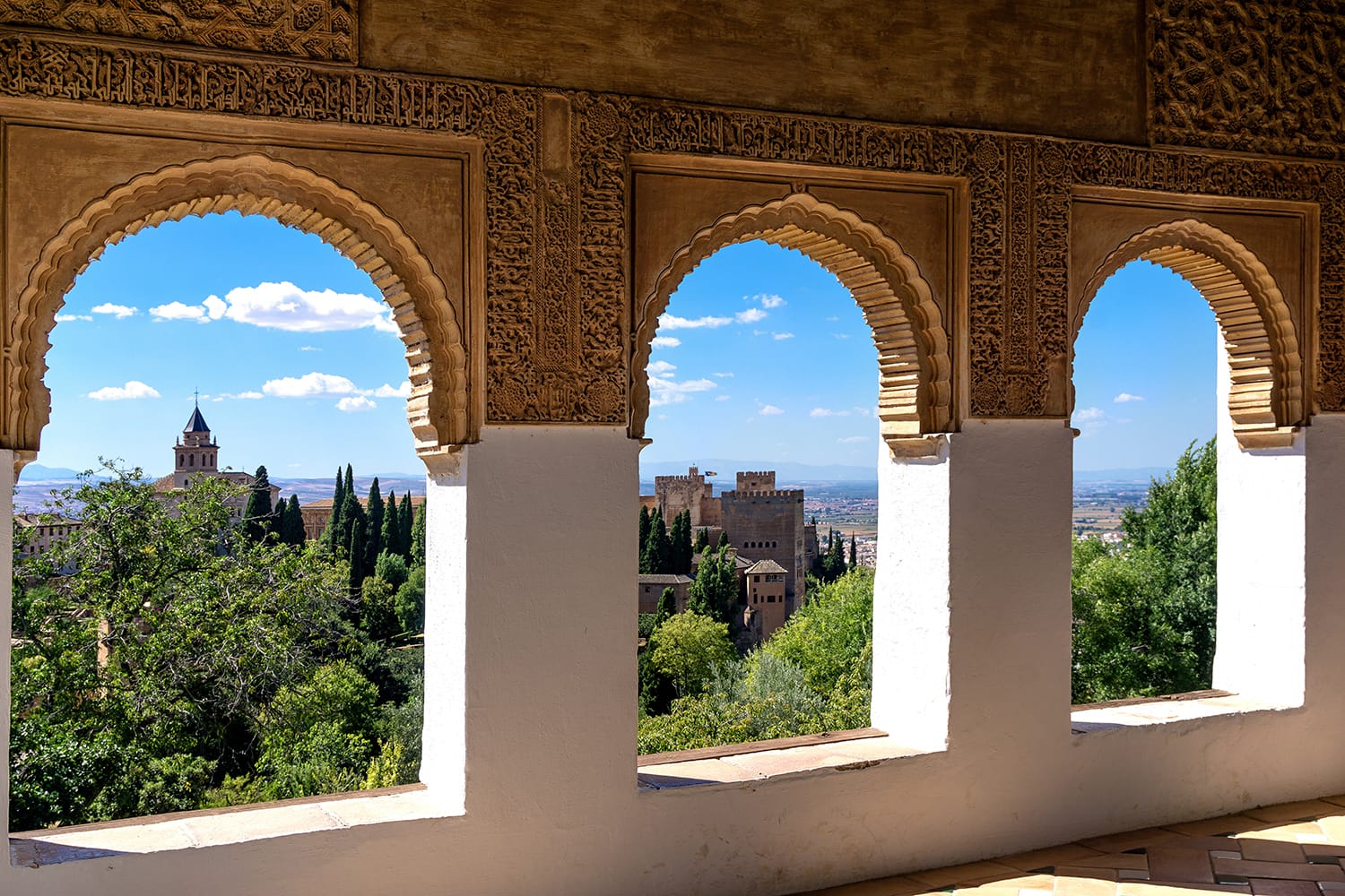 Stone arches in the world-famous Alhambra in Granada with beautiful views of the fortress and Granada, Spain