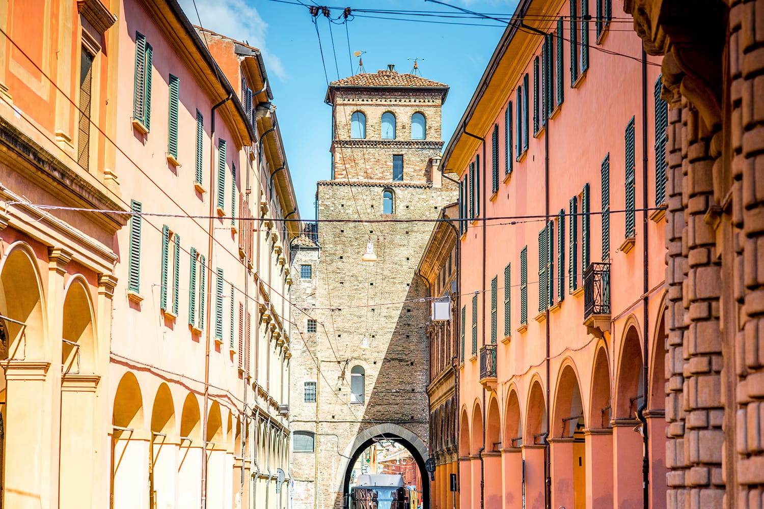 Street view with city gate and galleries in Bologna in Italy