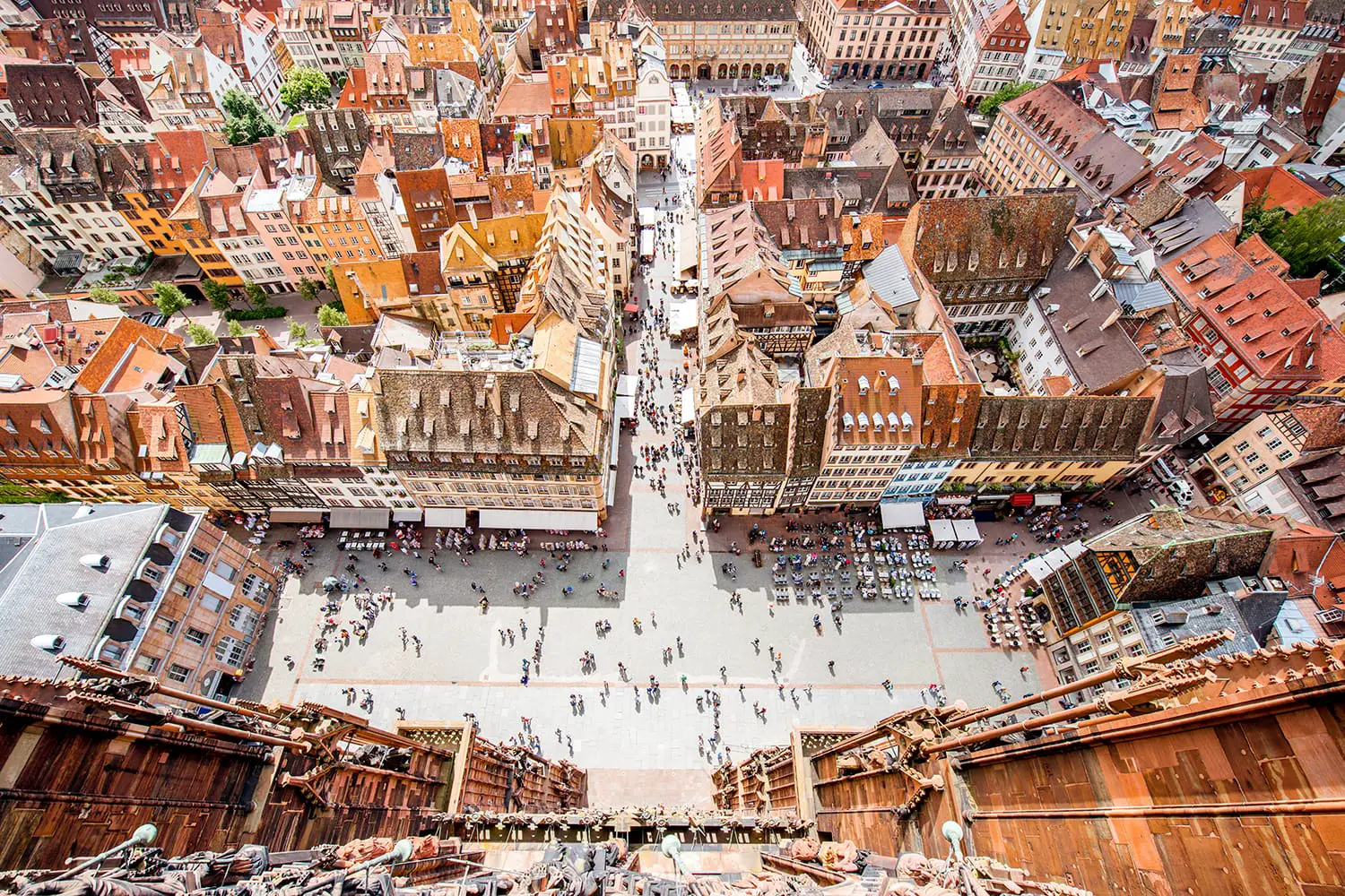 Top cityscape view on the cathedral square crowded with people in the old town of Strasbourg city, France