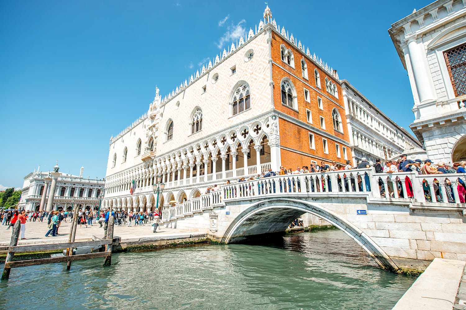 View on Doges palace with tourists walk on the bridge and San Marco square in Venice, Italy
