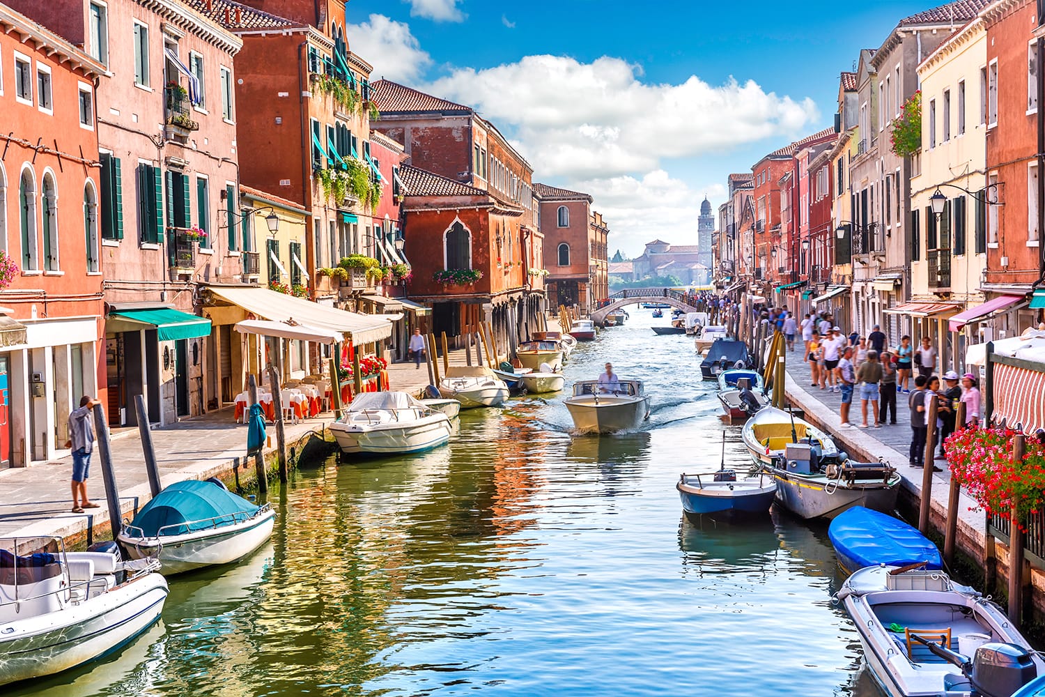 Island murano in Venice Italy. View on canal with boat and motorboat water.