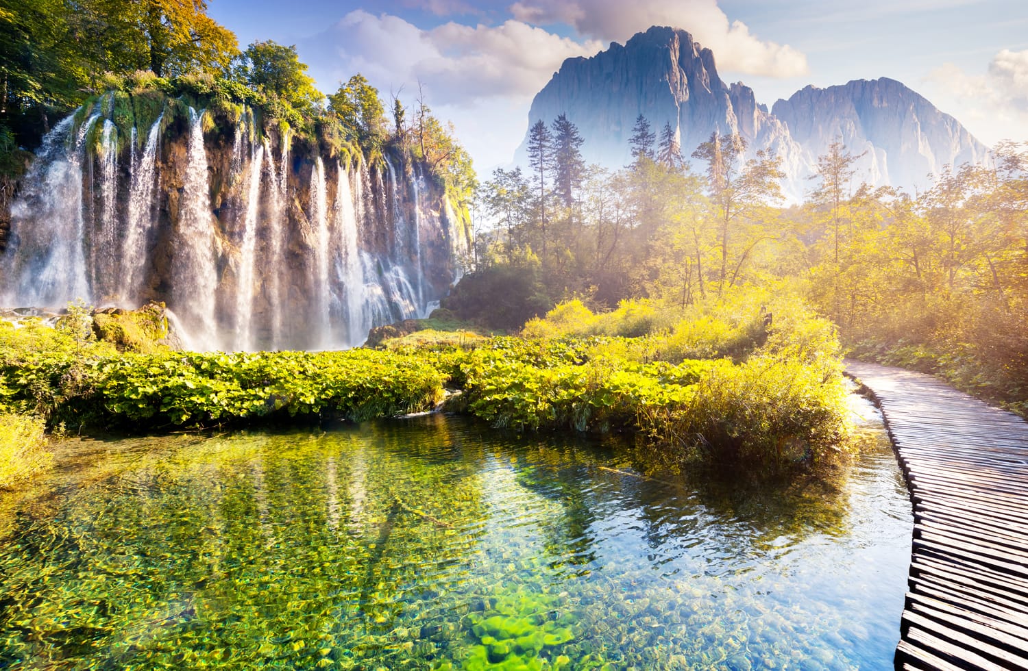Majestic view on waterfall with turquoise water, sunny beams in the Plitvice Lakes National Park, Croatia.