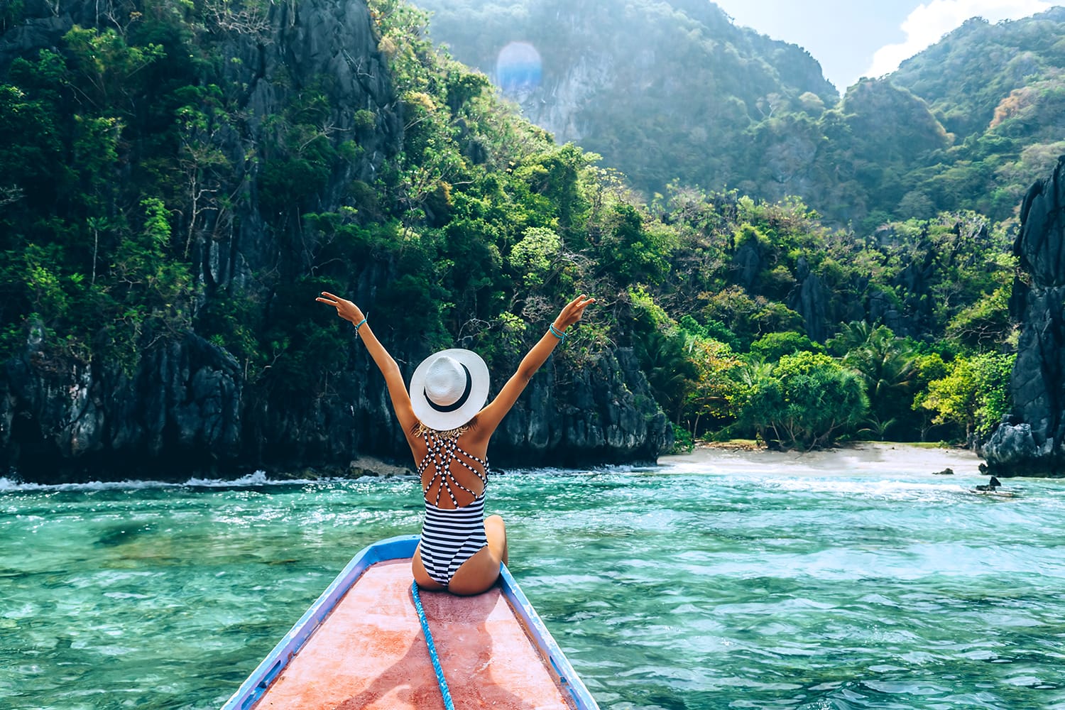 Πίσω όψη της νεαρής γυναίκας με καπέλο που χαλαρώνει στη βάρκα και κοιτάζει το νησί. Ταξιδιωτική περιήγηση στην Ασία: El Nido, Palawan, Φιλιππίνες