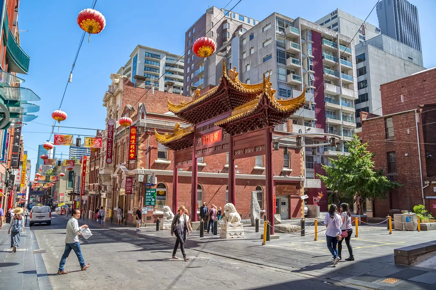 People walk down the Chinatown main street by the Heaven archway, gift from Jiangsu province. Melbourne, Australia