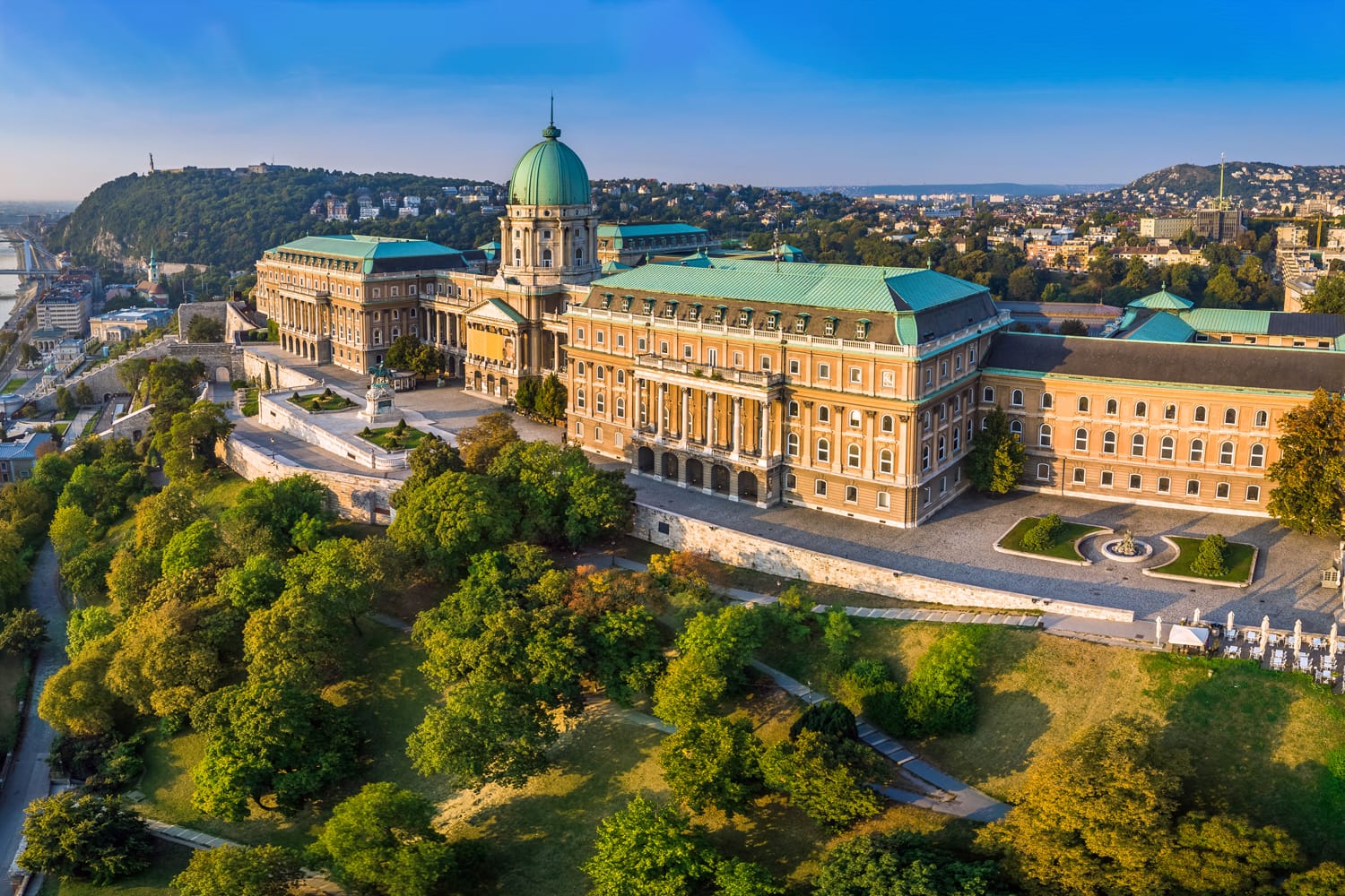 Aerial panoramic view of the beautiful Buda Castle Royal Palace at sunrise with Gellert Hill and Statue of Liberty at background