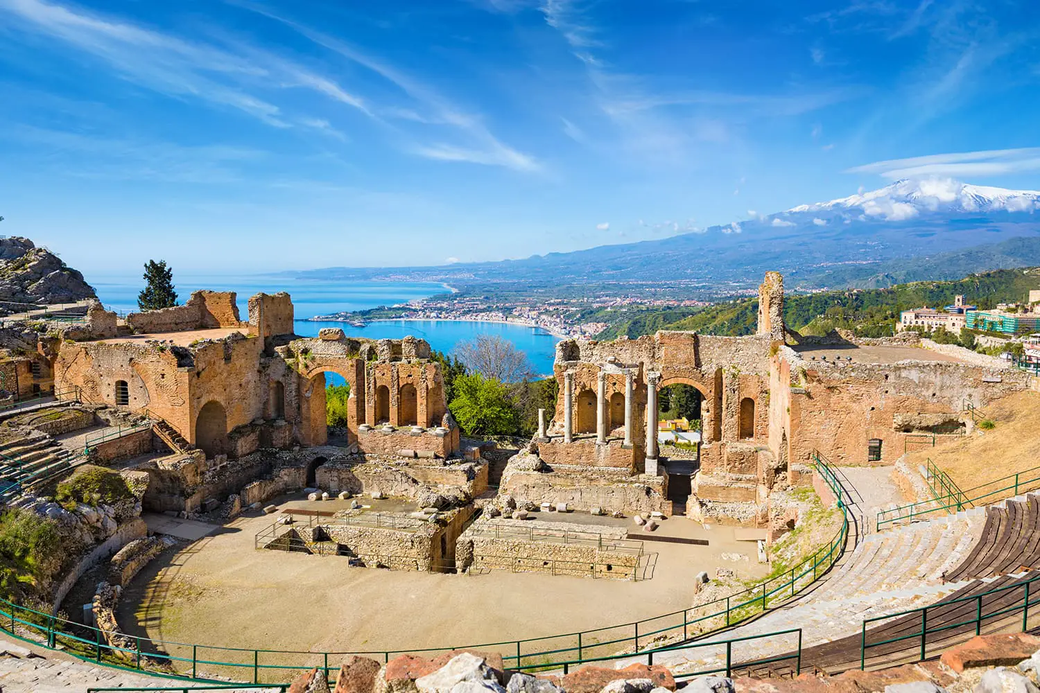 Ruins of Ancient Greek theatre in Taormina on background of Etna Volcano, Italy