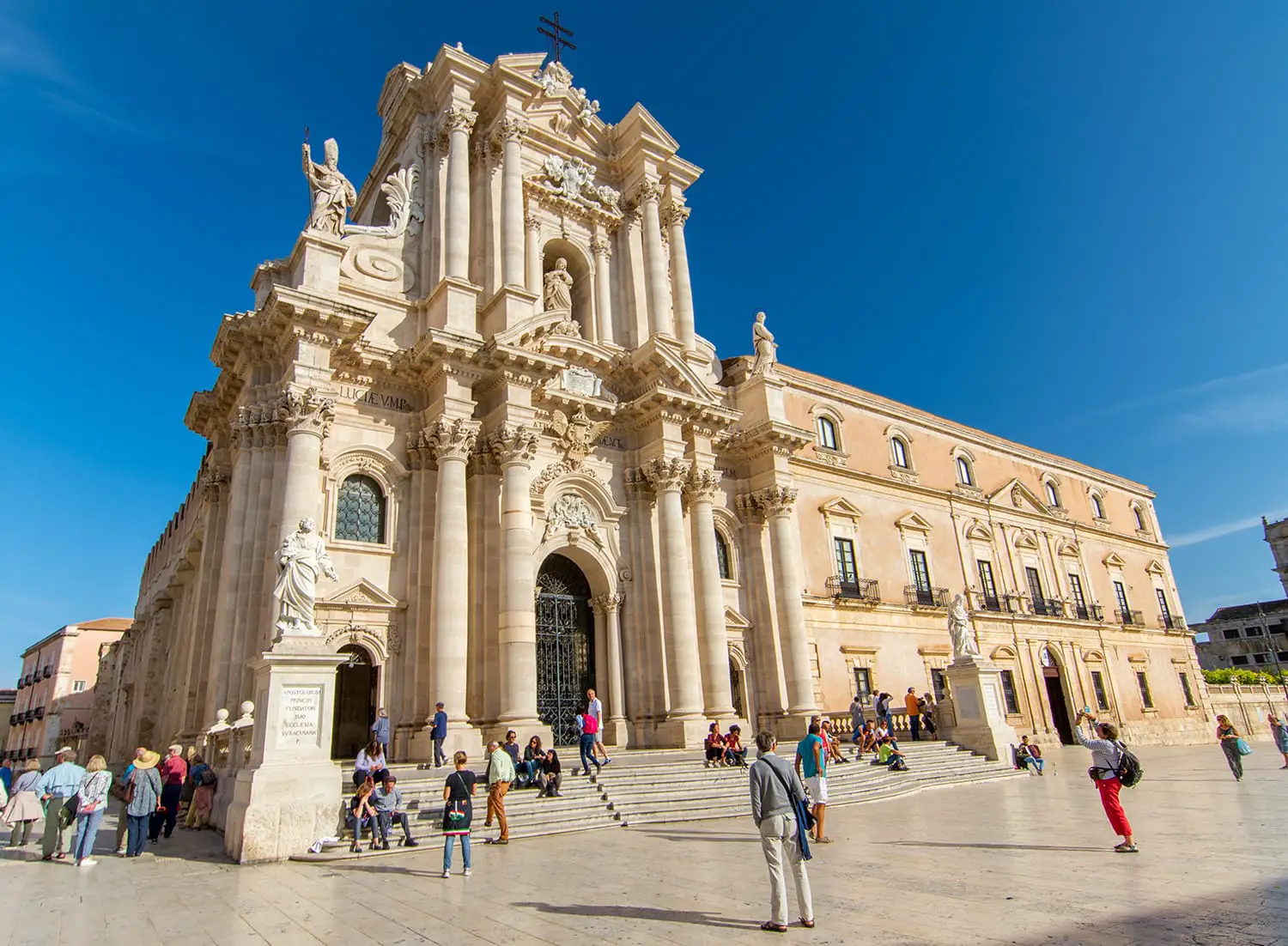 Tourists visiting Duomo Square in Ortigia, the historical city centre of Syracuse, Italy