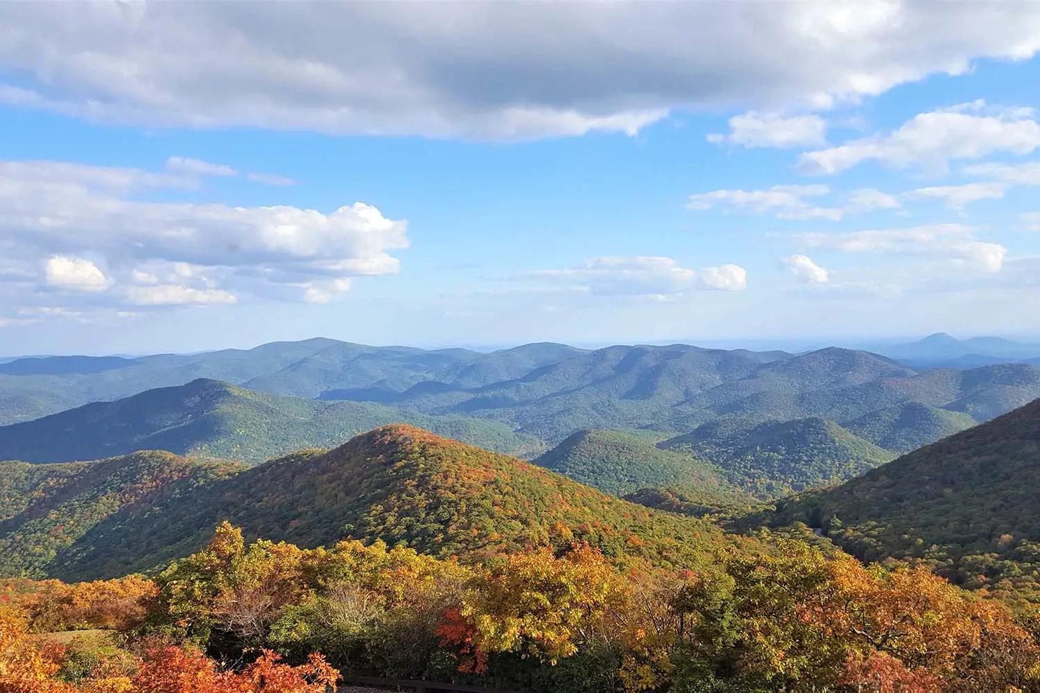 The fantastic view from Brasstown Bald mountain ( the highest mountain in Georgia) colorful in Fall season with white fluffy clouds and blue sky, North Georgia in USA.