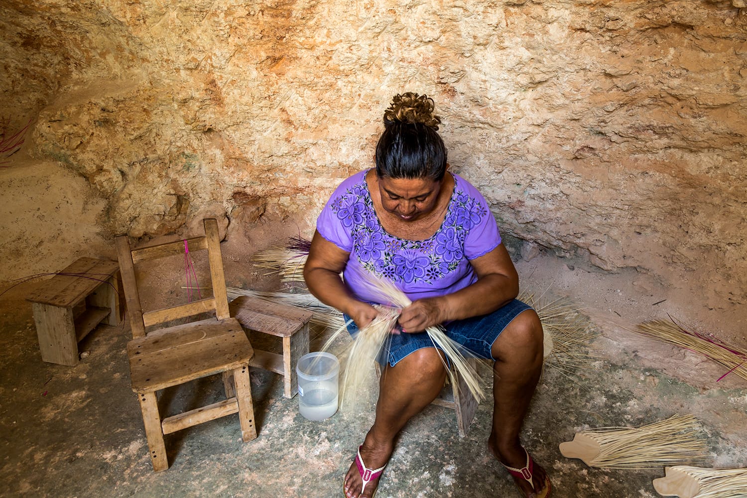Artisan in cave weaving straw to make a hat in Becal, Mexico