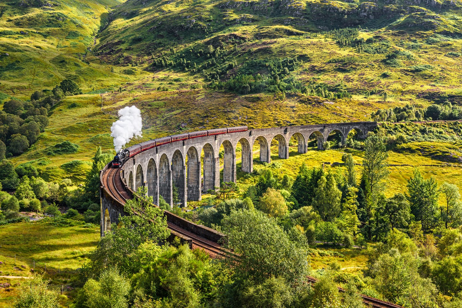 Σιδηροδρομική οδογέφυρα Glenfinnan στη Σκωτία με το ατμοκίνητο τρένο Jacobite να περνά