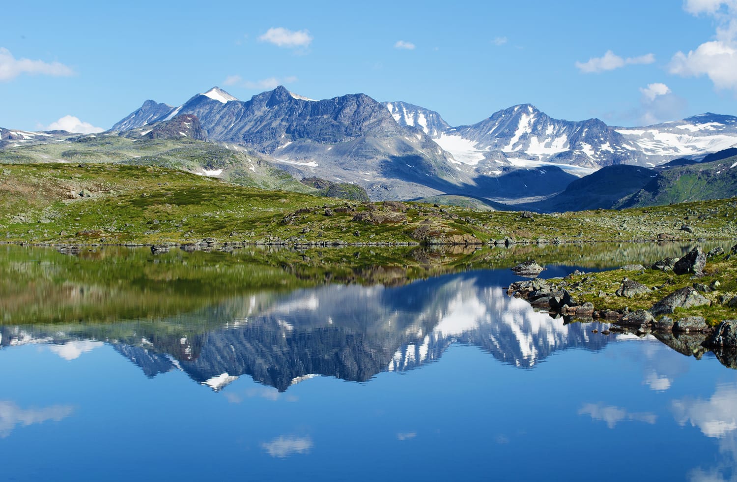 Αντανάκλαση της αλυσίδας βουνών σε μια μικρή λίμνη στο εθνικό πάρκο Jotunheimen στη Νορβηγία.