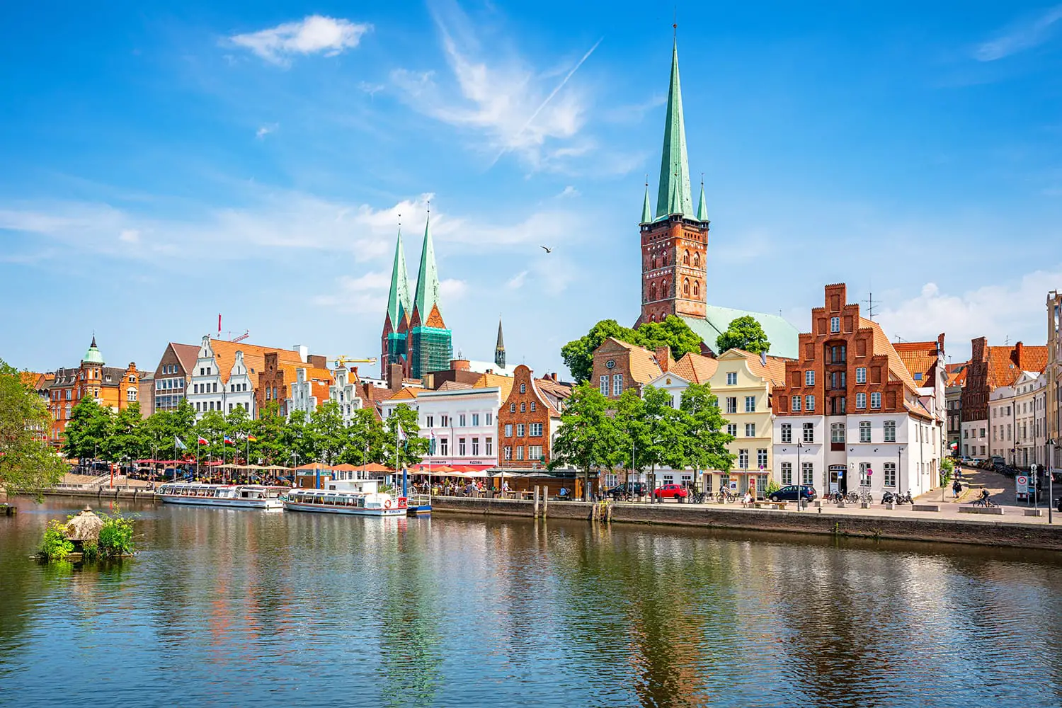 Classic panoramic view of historic skyline of hanseatic town of Lübeck with famous St. Mary's Church on a beautiful sunny day with blue sky in summer, Schleswig-Holstein, Germany
