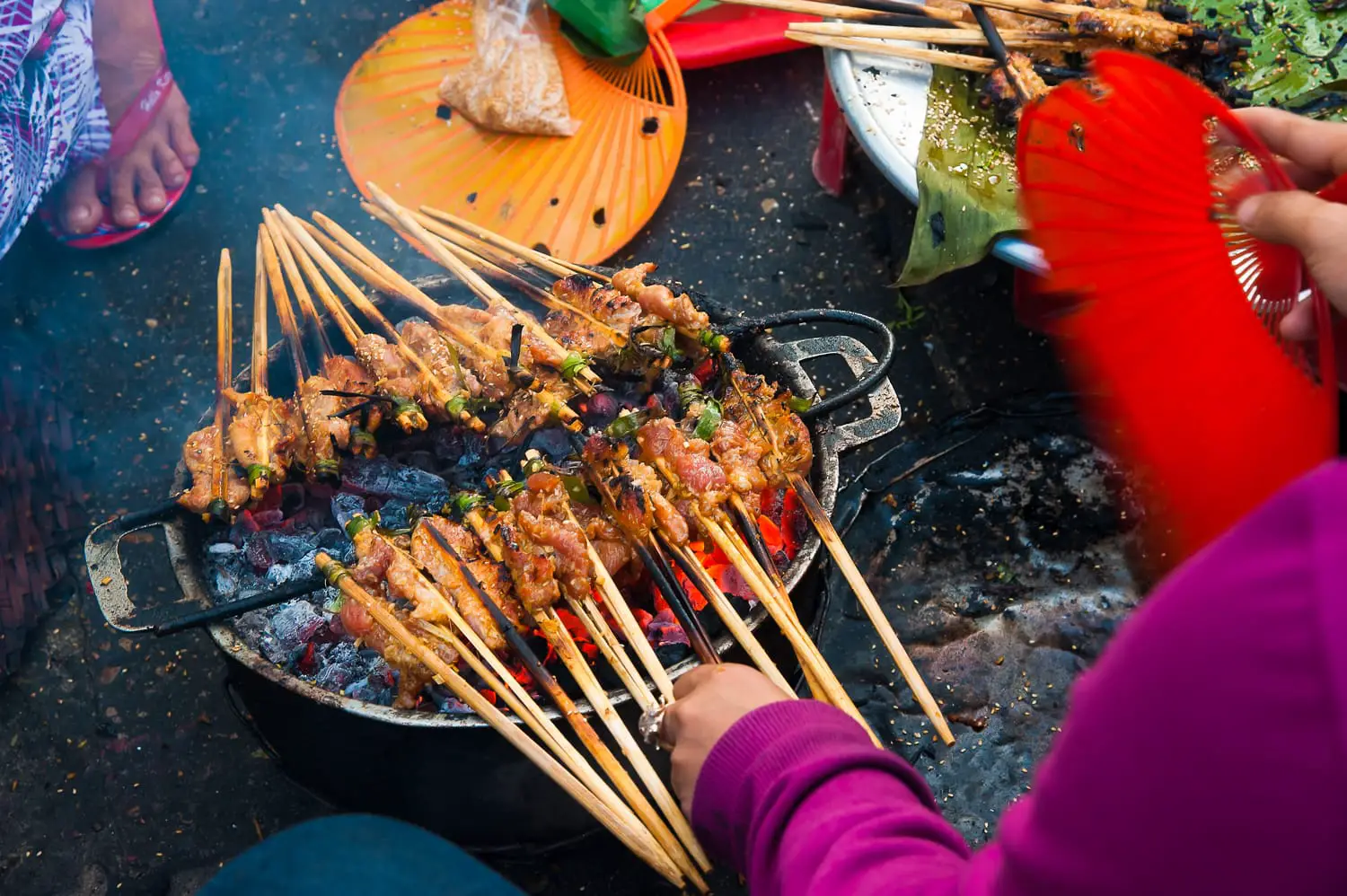 Hawker prepare the skewered grilled meats at street of Hoi An, a local delicacy of Vietnam