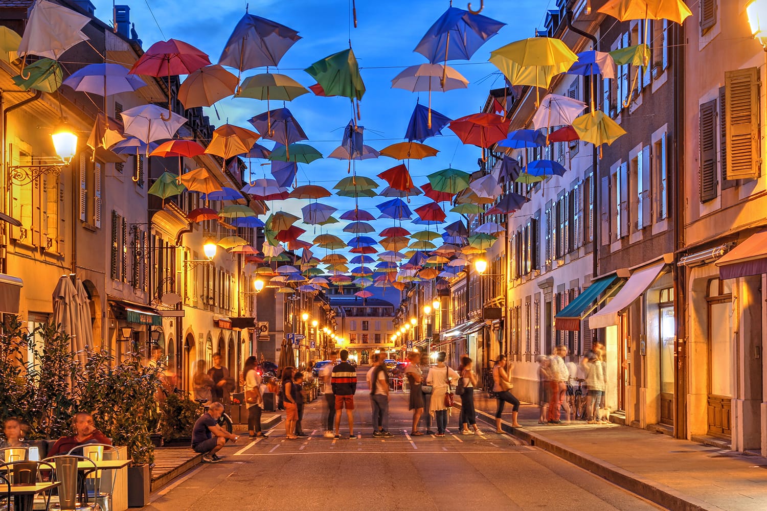 Σκηνή νύχτας στο Carouge, Γενεύη, Ελβετία κατά μήκος της Rue Saint Joseph καλυμμένη προσωρινά από πολύχρωμες ομπρέλες