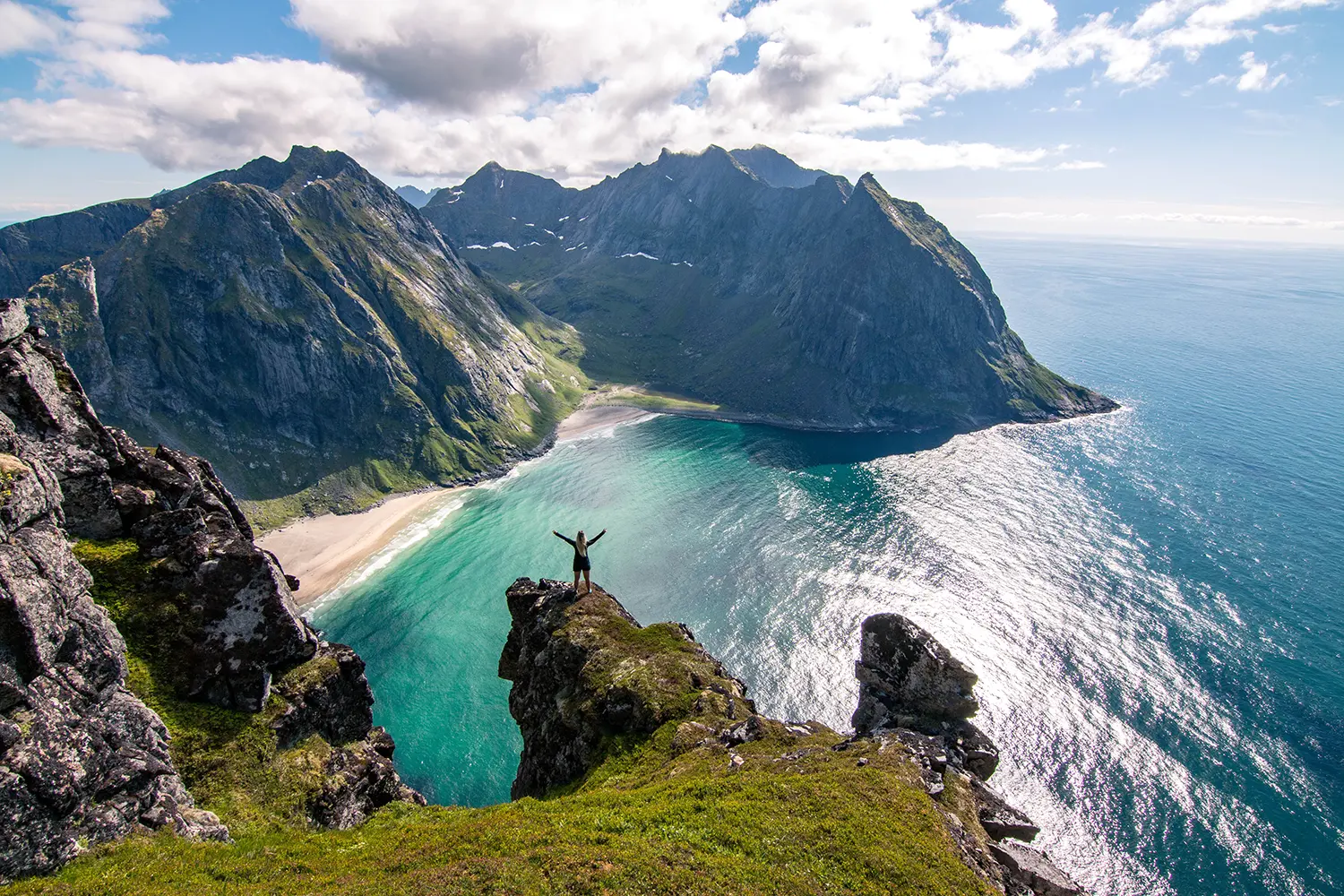 Γυναίκα που κοιτάζει το εκπληκτικό καλοκαιρινό τοπίο και θέα προς την παραλία Kvalvika στο Lofoten, Νορβηγία