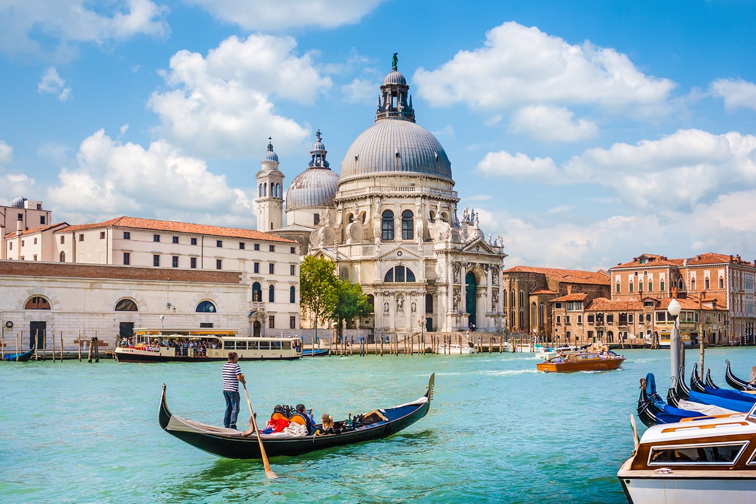 Όμορφη θέα της παραδοσιακής γόνδολας στο Canal Grande με τη Basilica di Santa Maria della Salute στο βάθος μια ηλιόλουστη μέρα στη Βενετία, Ιταλία