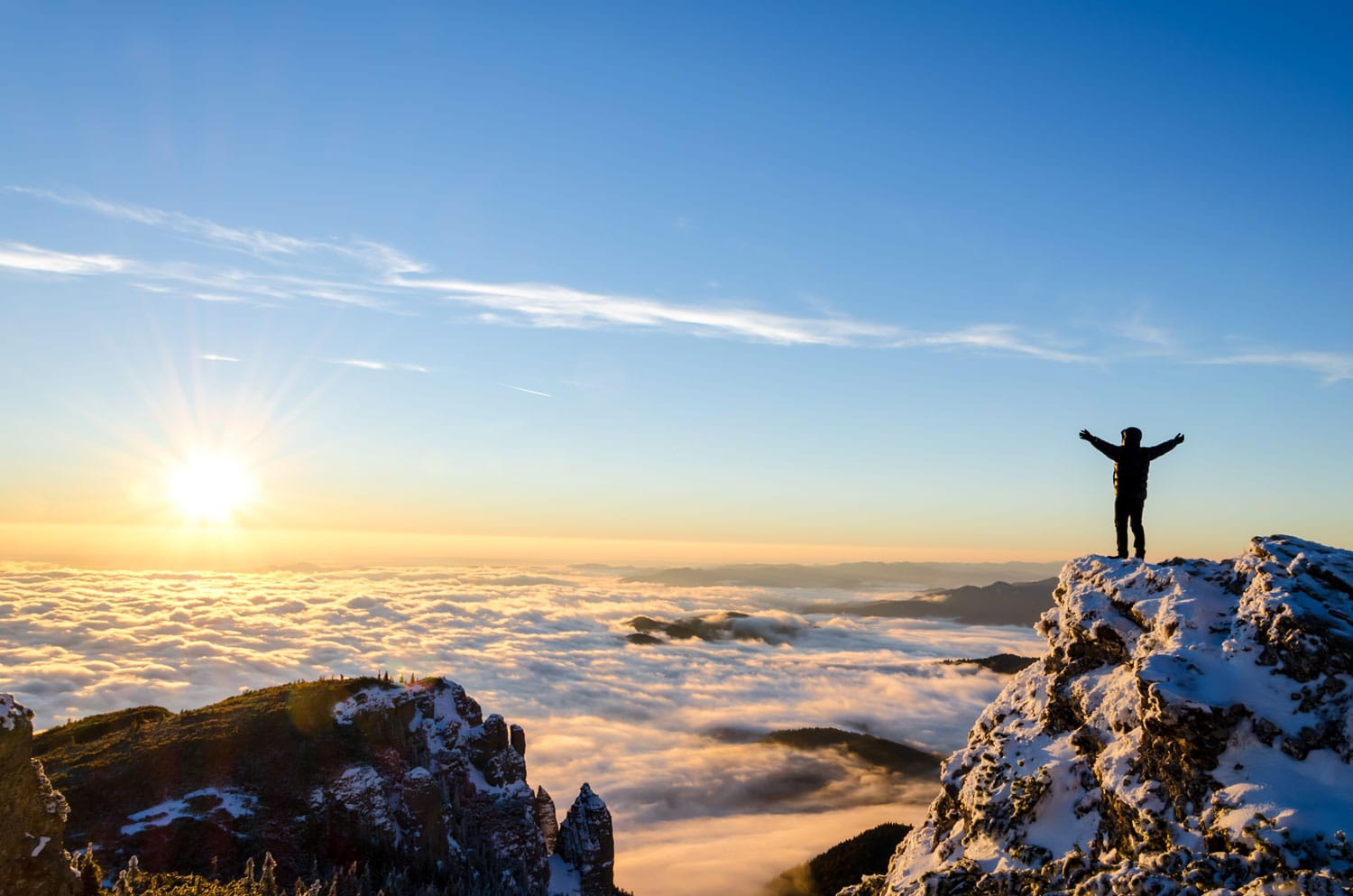 πεζοπόρος που γιορτάζει την επιτυχία στην κορυφή ενός βουνού σε μια μαγευτική ανατολή