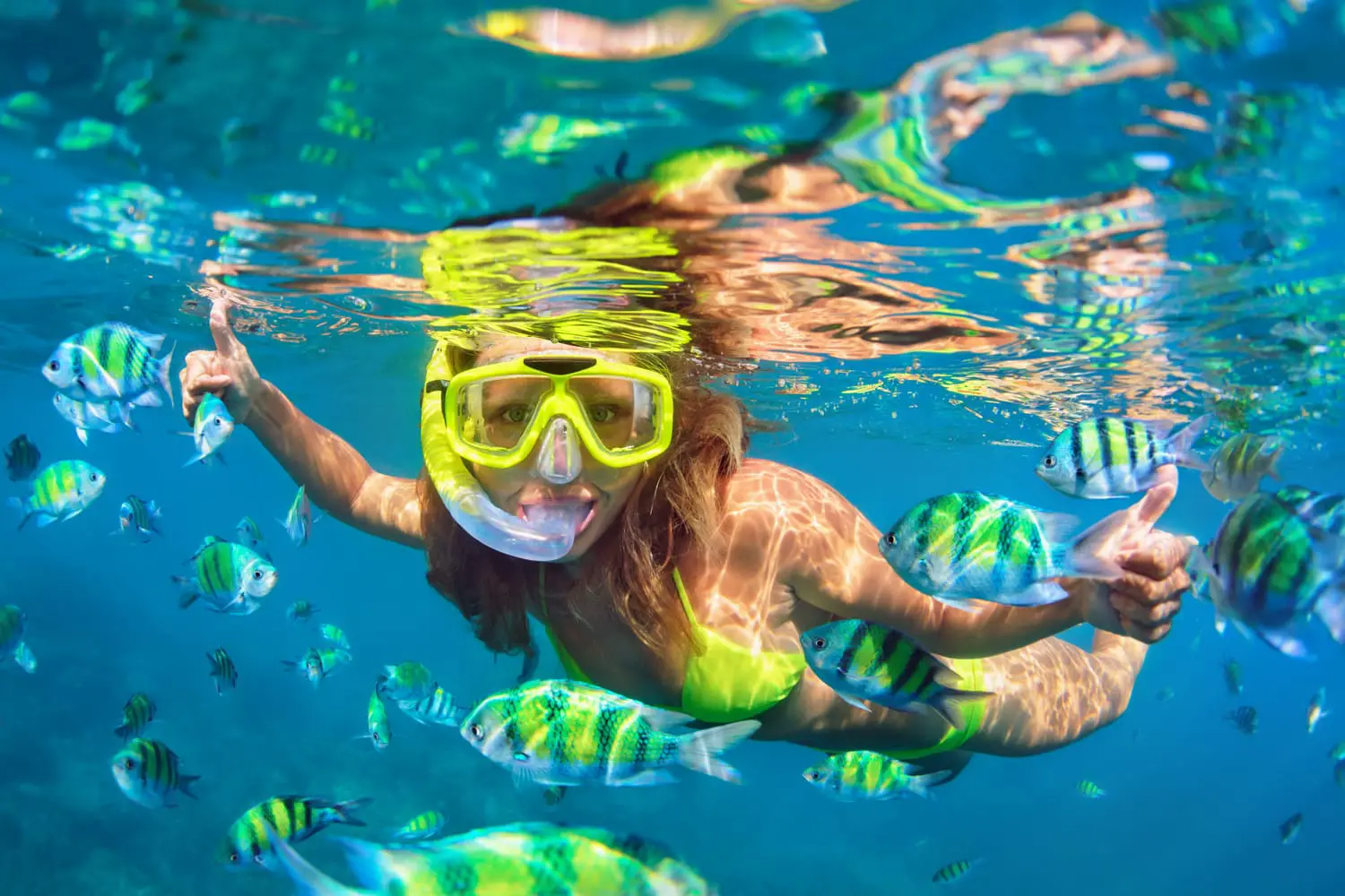 κορίτσι με μάσκα κολύμβησης με αναπνευστήρα βουτιά υποβρύχια με ψάρια